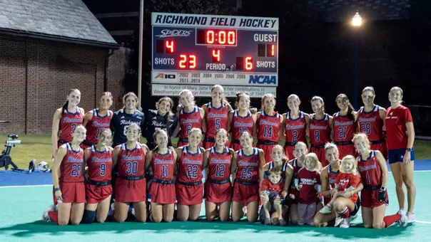2026 Spider field hockey poses in front of the scoreboard after beating VCU to close out the regular season