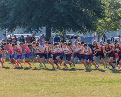 The men's cross country team sprints at the start of a race