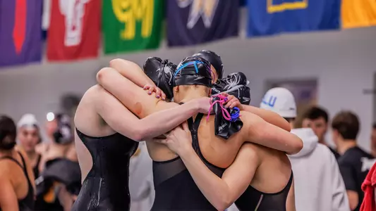 Richmond swim team huddling during the 2026 Atlantic 10 Championships
