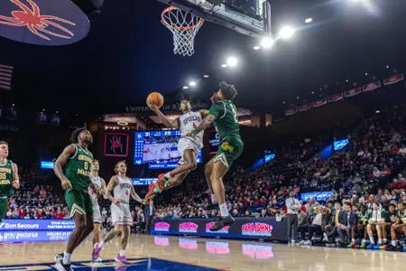AJ Lopez floats through the defense towards the goal for a dunk over his George Mason defender