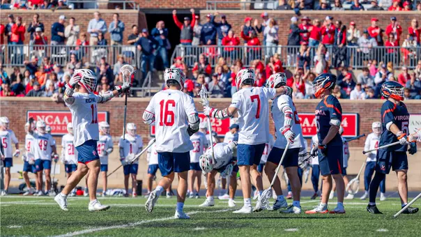 Men's lacrosse team celebrates a goal against Virginia