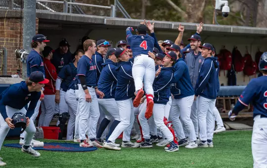 Number four, RJ Johnson Jr jumps into the arms of his teammates to celebrate his home run