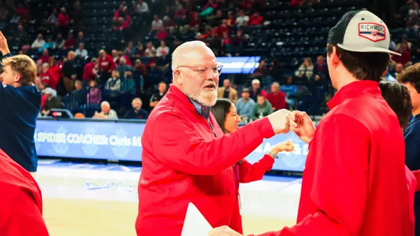 John Hardt fist bumps a student during a procession
