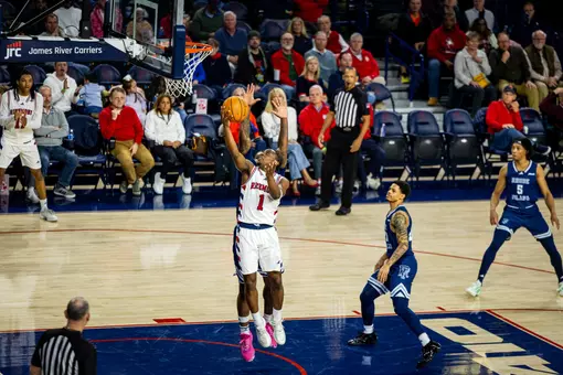 Mikkel Tynes shoots a reverse layup against Rhode Island