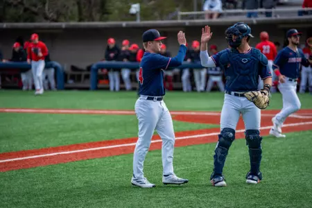 Glenn Smith high-fives his catcher Dylan Winebrenner as he comes off the field
