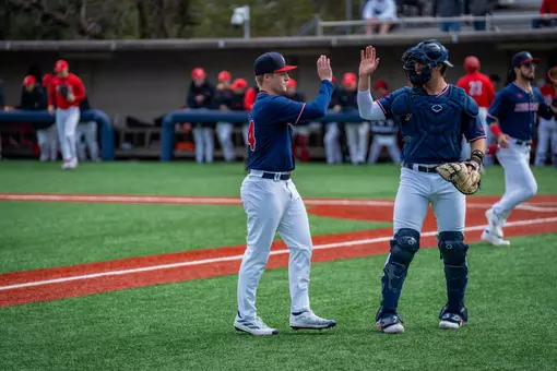Glenn Smith high-fives his catcher Dylan Winebrenner as he comes off the field