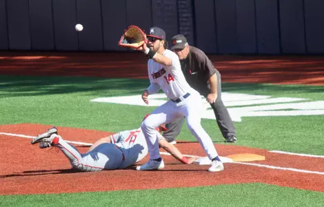 Ryan Recio catches the ball at first on a pick off attempt as the runner dives back into the base