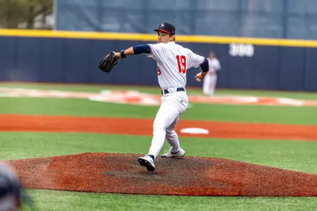 Angel Santiago-Cruz looks over his shoulder to throw the pitch towards home