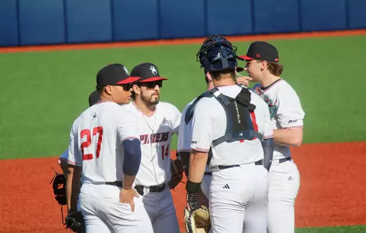 Spider baseball infielders huddle during a officials review
