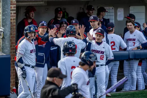Spider Baseball high fives a teammate as they head into the dugout after scoring