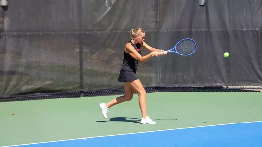 Lainey O'Neil hitting a ball back across the court