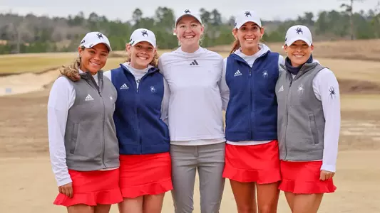The women's golf team poses on a green at Old Barnwell