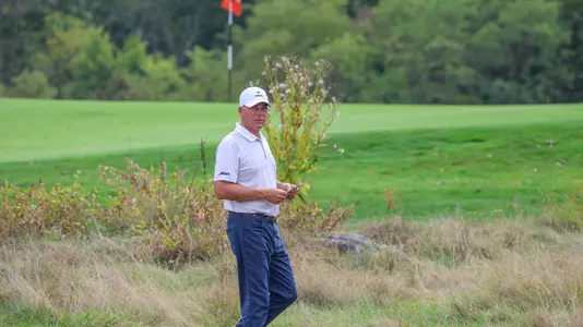 Adam Decker walks near a green