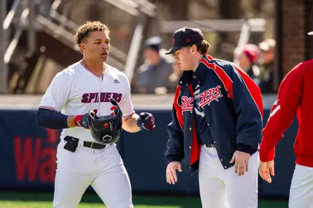 Khris Morris gets a high-five from Chayse Gruber as he heads to the dugout