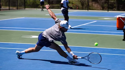 Charlie Burdell reaching for a tennis ball