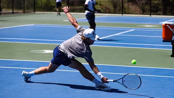 Charlie Burdell reaching for a tennis ball