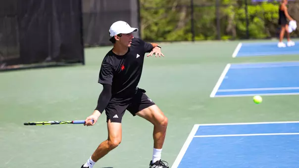 Grant Cohen hitting a ball back across the court