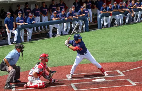 Dylan Winebrenner stands at the plate while the Spiders dugout watches his at bat