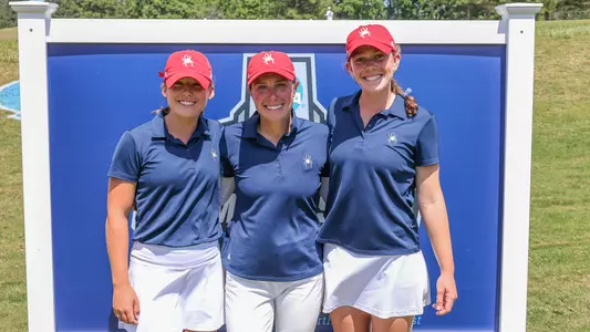 Calle Barlow poses with two Spider golfers in front of the NCAA regionals sign