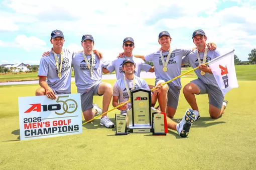 Men's golf poses on the green after winning the A-10 Championship