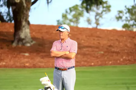 Adam Decker surveys the fairway with his arms crossed