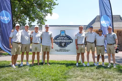 The men's golf team poses in front of an NCAA Regional sign at Bermuda Run Country Club