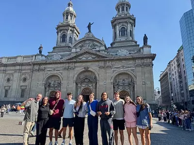 Spider student-athletes pose in front of a cathedral in Chile