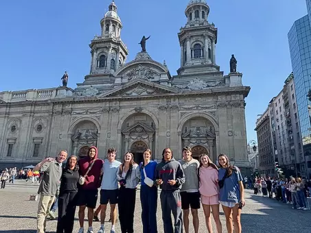 Spider student-athletes pose in front of a cathedral in Chile
