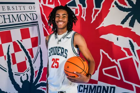 Jaden Shoultz poses with a ball in front of a Richmond Athletics backdrop