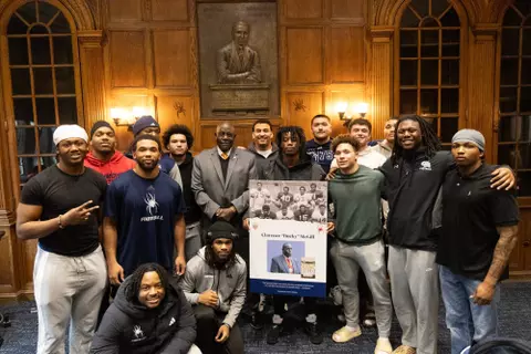 Members of the football team pose with activist Bucky McGill