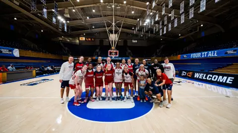 The women's basketball team poses on the court at Cameron Indoor Stadium