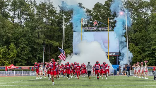 Football team running out of the tunnel during a game at Robins Stadium in 2025