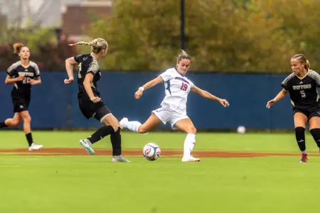 Paige West strikes the ball amid a sea of defenders