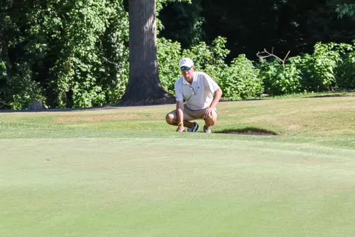 Adam Decker squatting by the green