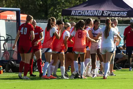 Kingsley Hughes embraces her teammates on the bench after scoring
