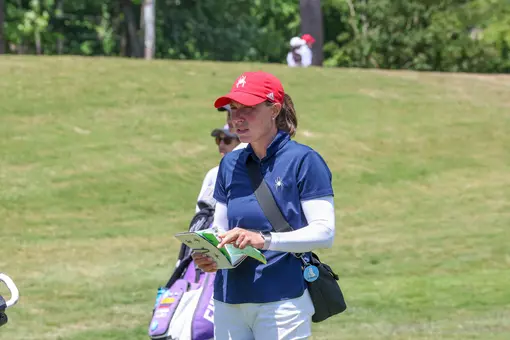 Calle Barlow checks her yardage book on the fairway