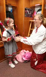 Alabama assistant coach Vann Stuedeman welcomes Krystin to her new locker.