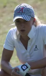 Golfer crouched evaluating her shot