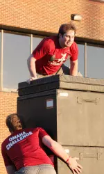 Senior pitcher Nathan Kilcrease clears the 7-foot wall to begin the obstacle course.