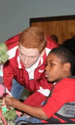 Freshman pitcher/infielder Spencer Turnbull helping decorate the Christmas tree at Sprayberry.