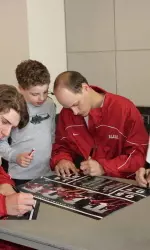 Jonathan Smart signs an autograph for a young fan at the Fan Day Barbeque.