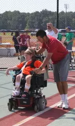 Freshman infielder Daniel Cucjen helping one of the Mircal League players around the bases.