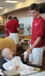 Nick Eicholtz handing off a signed Alabama baseball.