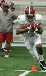 RB Derrick Henry goes through drills on Saturday under the watchful eye of assistant coach Burton Burns.