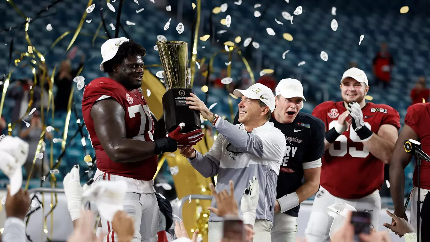 Nick Saban and Alex Leatherwood holding the National Championship trophy