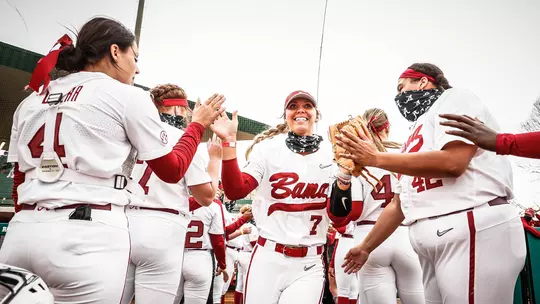 Softball team cheering on Bailey Dowling as she runs onto the field