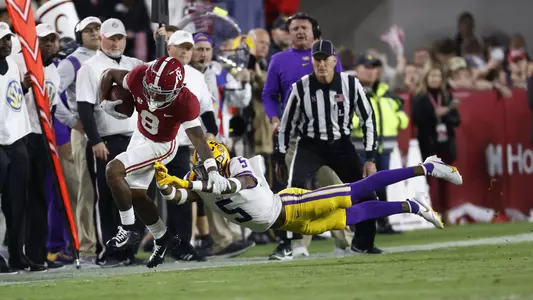 Alabama wide receiver John Metchie III dodging a tackle from LSU