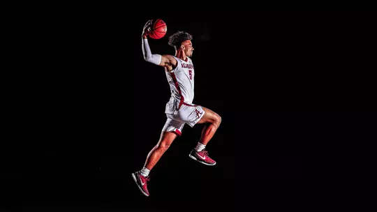 Jaden Shackelford jumping through the air against a black background