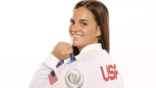 Rhyan White holding her silver medal over her shoulder