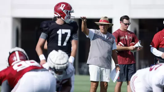 Nick Saban standing behind Paul Tyson at practice